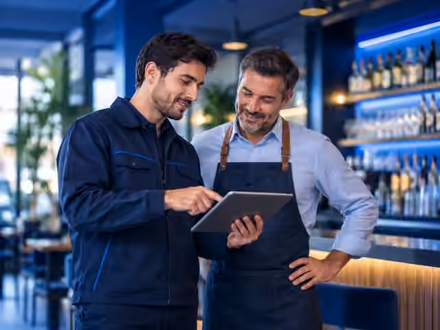 Técnico y responsable de un bar coordinando la instalación y la puesta en marcha del servicio